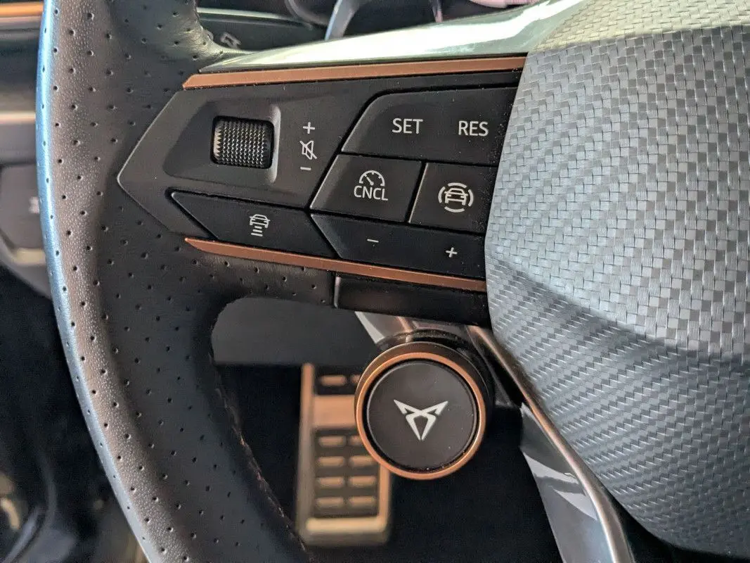 Gros plan sur le volant perforé noir du CUPRA Formentor 2025 avec commandes du régulateur de vitesse et logo central.
