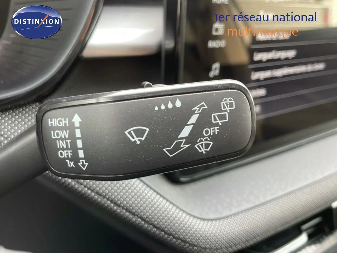 Gros plan sur la commande d’essuie-glace à gauche du volant dans l’habitacle d’une Skoda Fabia blanc glacier 2025.