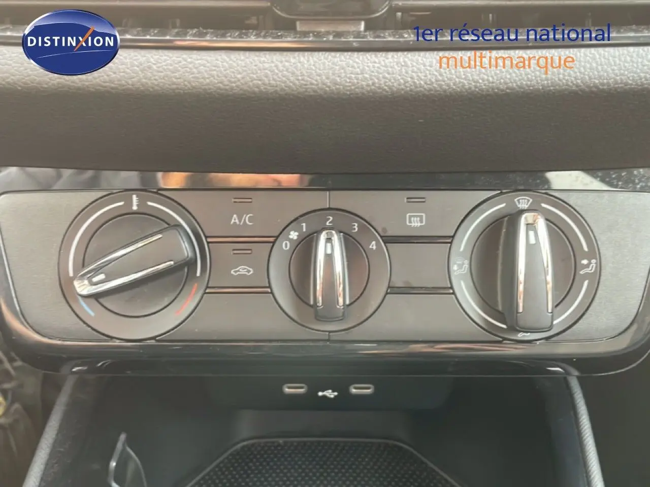 Gros plan sur les commandes de climatisation manuelle d'une Skoda Fabia blanche glacier, avec boutons rotatifs et ports USB visibles.