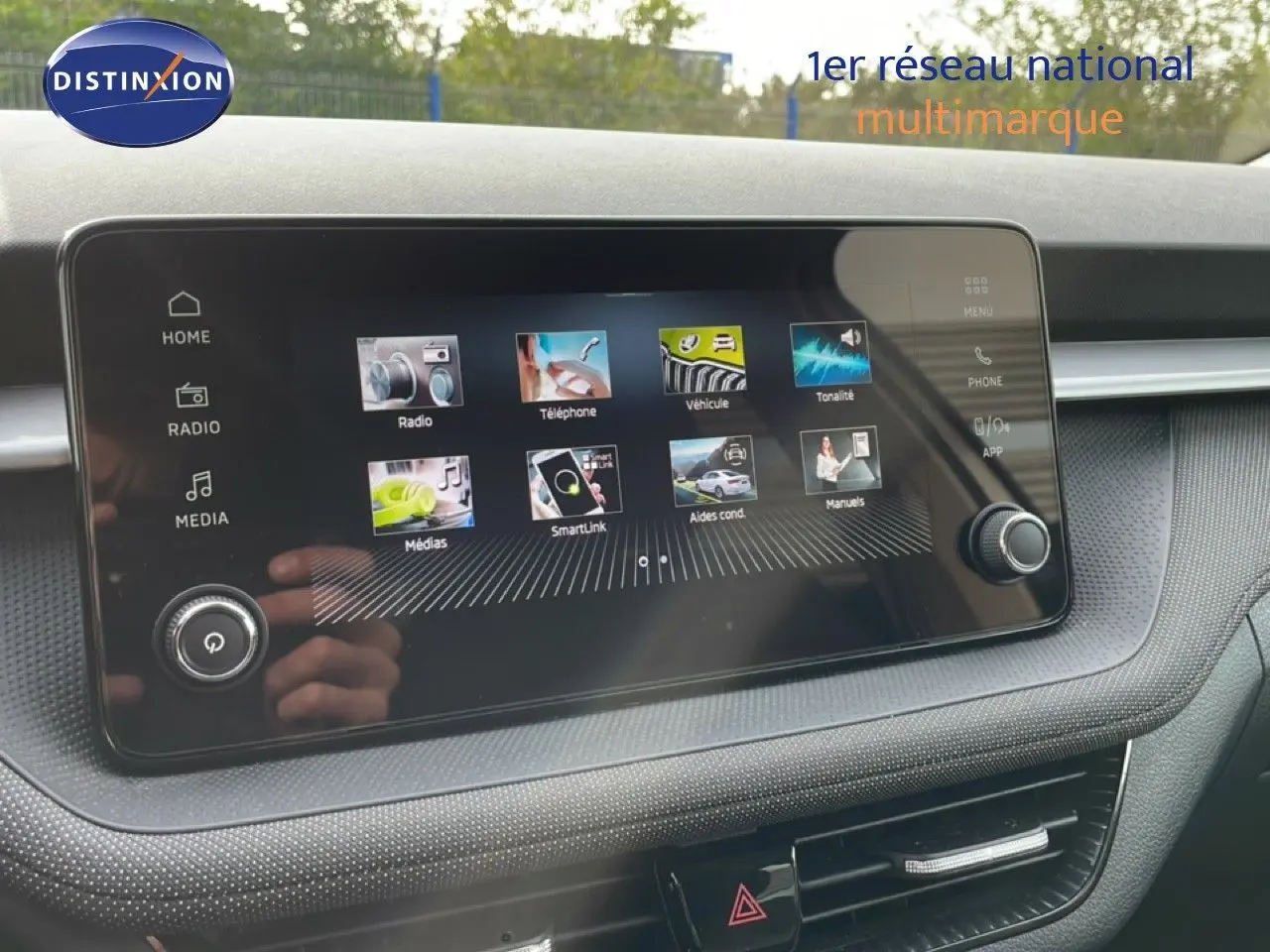 Écran tactile central du tableau de bord de la Skoda Fabia blanc glacier, affichant les options multimédia et véhicule.
