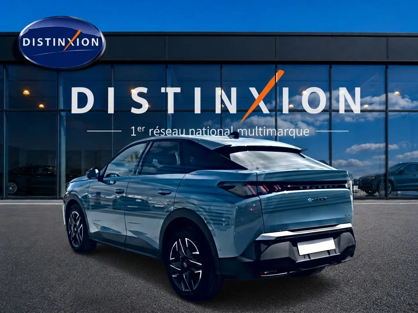 Peugeot 3008 bleu vue 3/4 arrière droit, avec jantes alu et becquet arrière, devant une vitrine Distinxion.