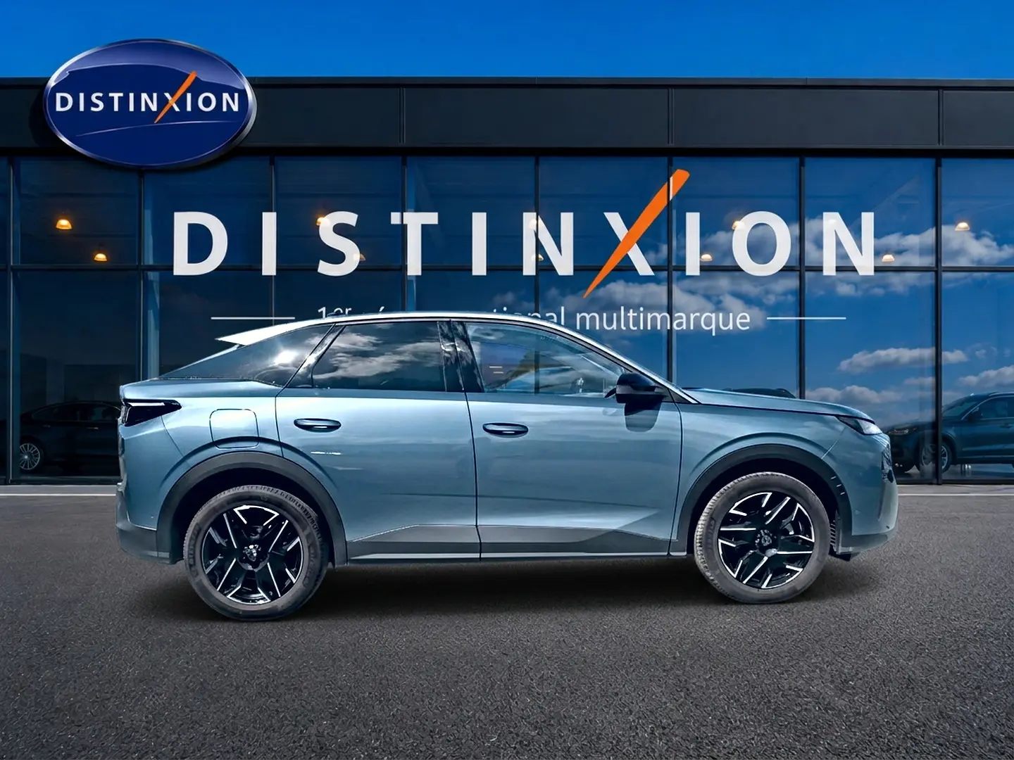 Profil droit du Peugeot 3008 1.2 hybrid 145 allure e-dcs6 bleu 2025 avec jantes alu noires devant une vitrine Distinxion.