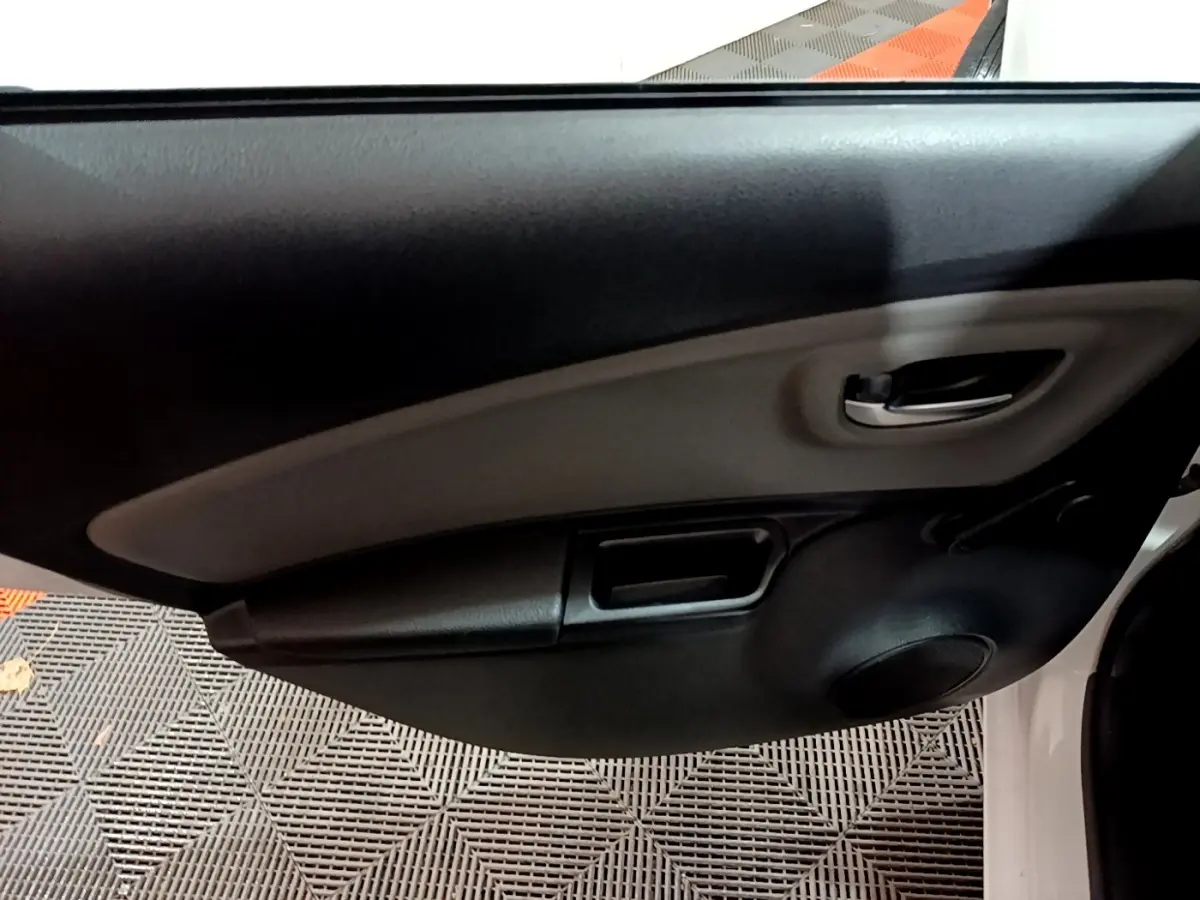 Détail de la porte avant gauche intérieure noire et grise d’une Toyota Yaris blanche hybride 2019.