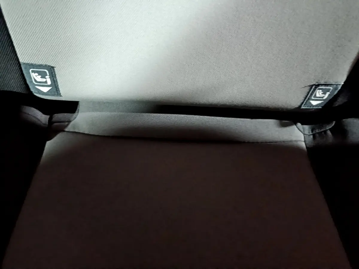 Gros plan sur la banquette arrière grise de la Toyota Yaris 1.5 Hybrid avec étiquettes Isofix visibles.