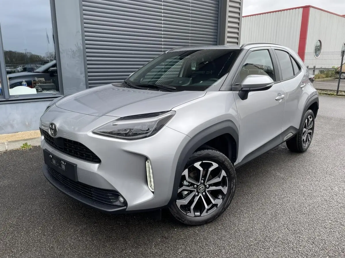 Toyota Yaris Cross gris clair vue 3/4 avant droit, avec toit noir et jantes alliage distinctives.
