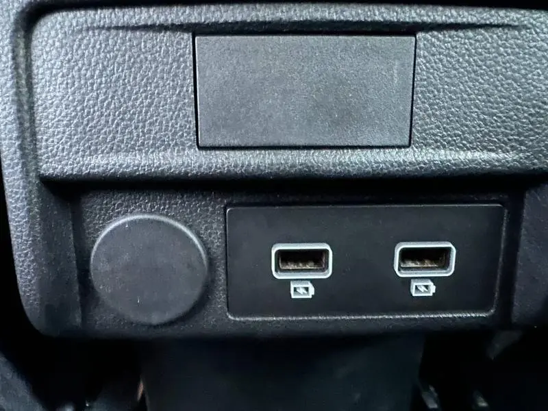 Gros plan sur deux ports USB et une prise 12V dans l'habitacle noir du Renault Arkana 2025.