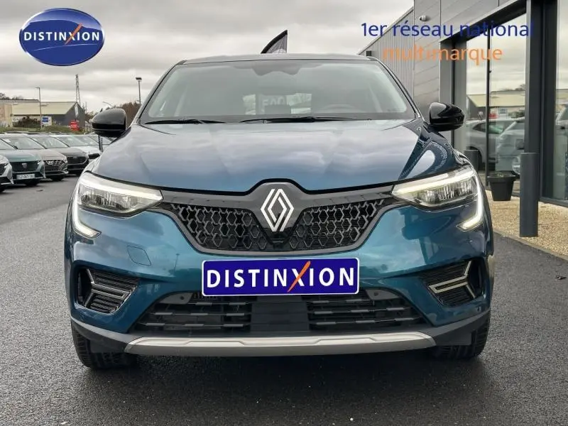 Vue frontale du Renault Arkana 2025 bleu Zanzibar avec calandre noire et feux LED allumés.