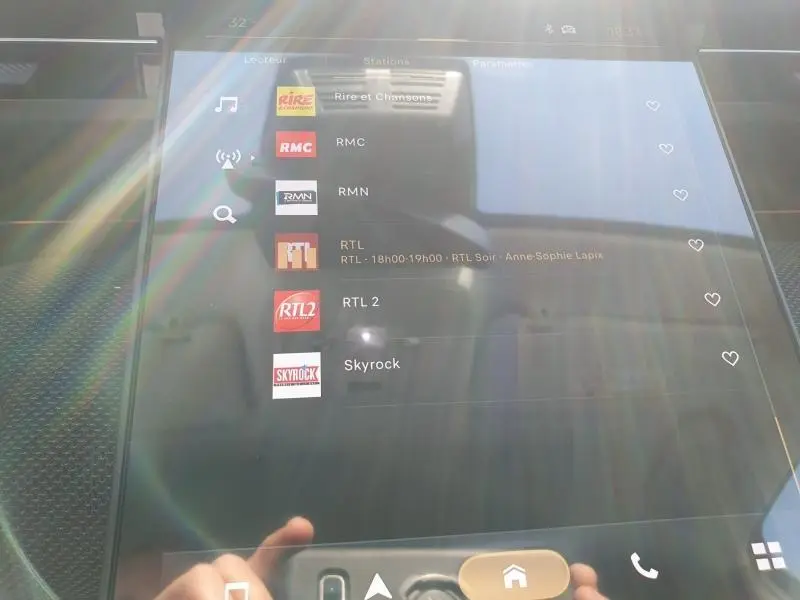 Écran tactile central du Citroën C5 Aircross 2026 affichant les stations radio, avec reflet et lumière ambiante.