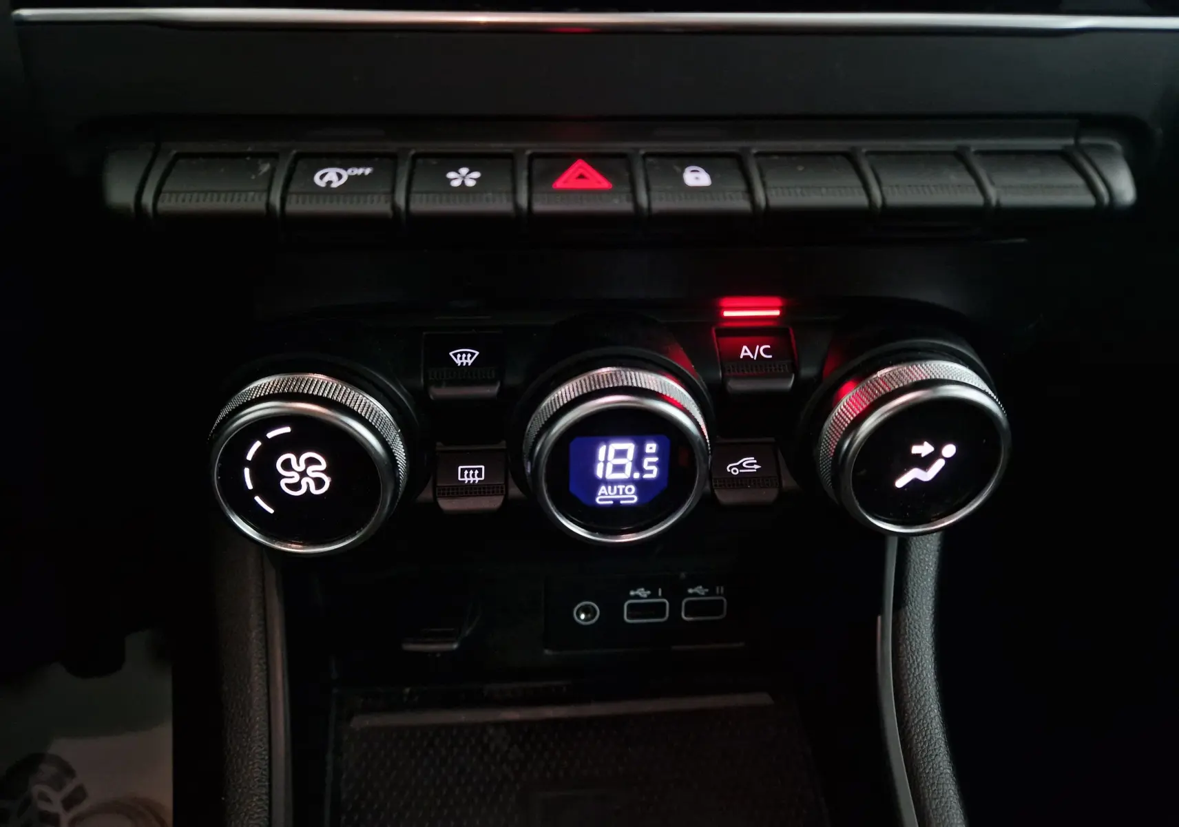 Gros plan sur la console de climatisation du Renault Captur 2024, avec réglage automatique à 18,5°C et boutons rétroéclairés.