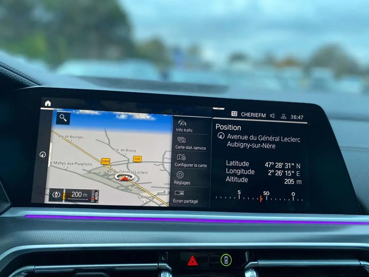 Écran de navigation intérieur du BMW X5 blanc 2022, affichant la carte et la position GPS sur le tableau de bord.