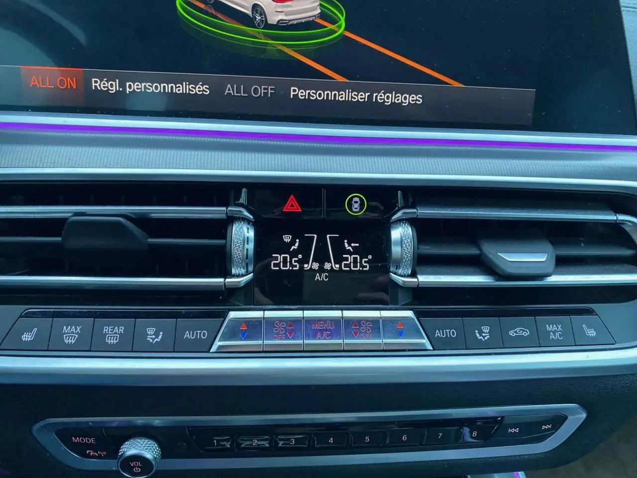 Vue rapprochée du tableau de bord du BMW X5 blanc 2022, affichant les commandes de climatisation et ventilation.