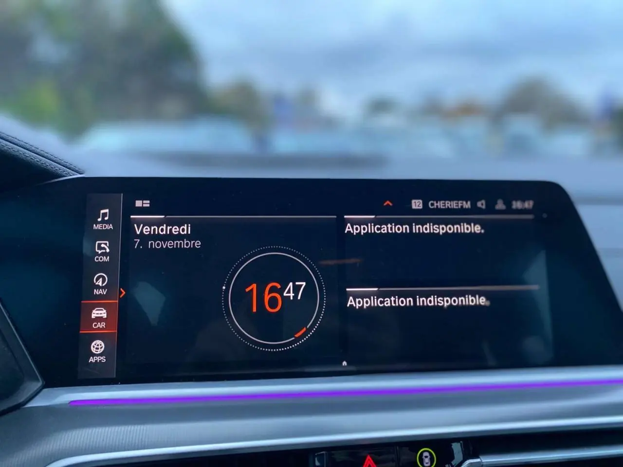 Écran central du tableau de bord du BMW X5 blanc 2022 affichant l'heure et un message d'application indisponible.