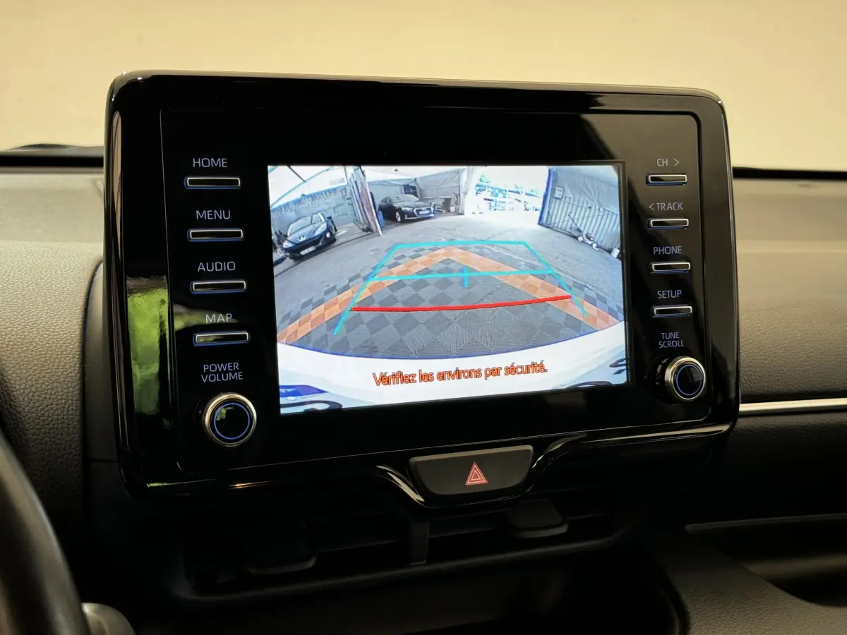 Écran tactile central affichant la caméra de recul dans l'habitacle d'une Toyota Yaris blanche hybride 2022.