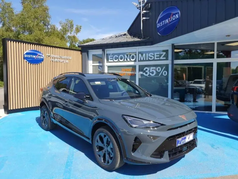 Vue 3/4 avant droit d'un CUPRA Formentor gris métallisé stationné devant un showroom avec logo Distinxion.