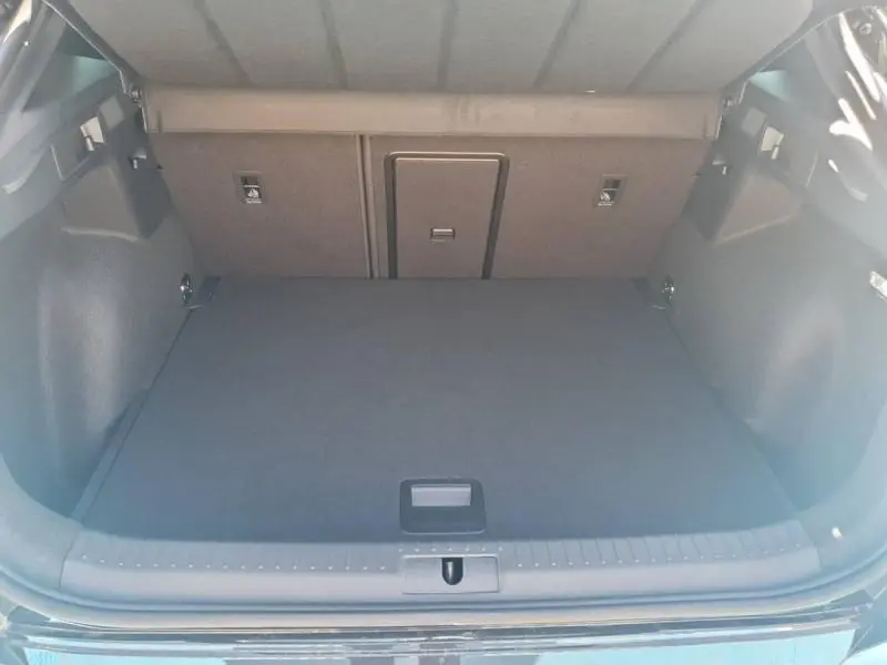 Vue intérieure du coffre spacieux et propre du CUPRA Formentor bleu, montrant le plancher et la banquette arrière rabattable.