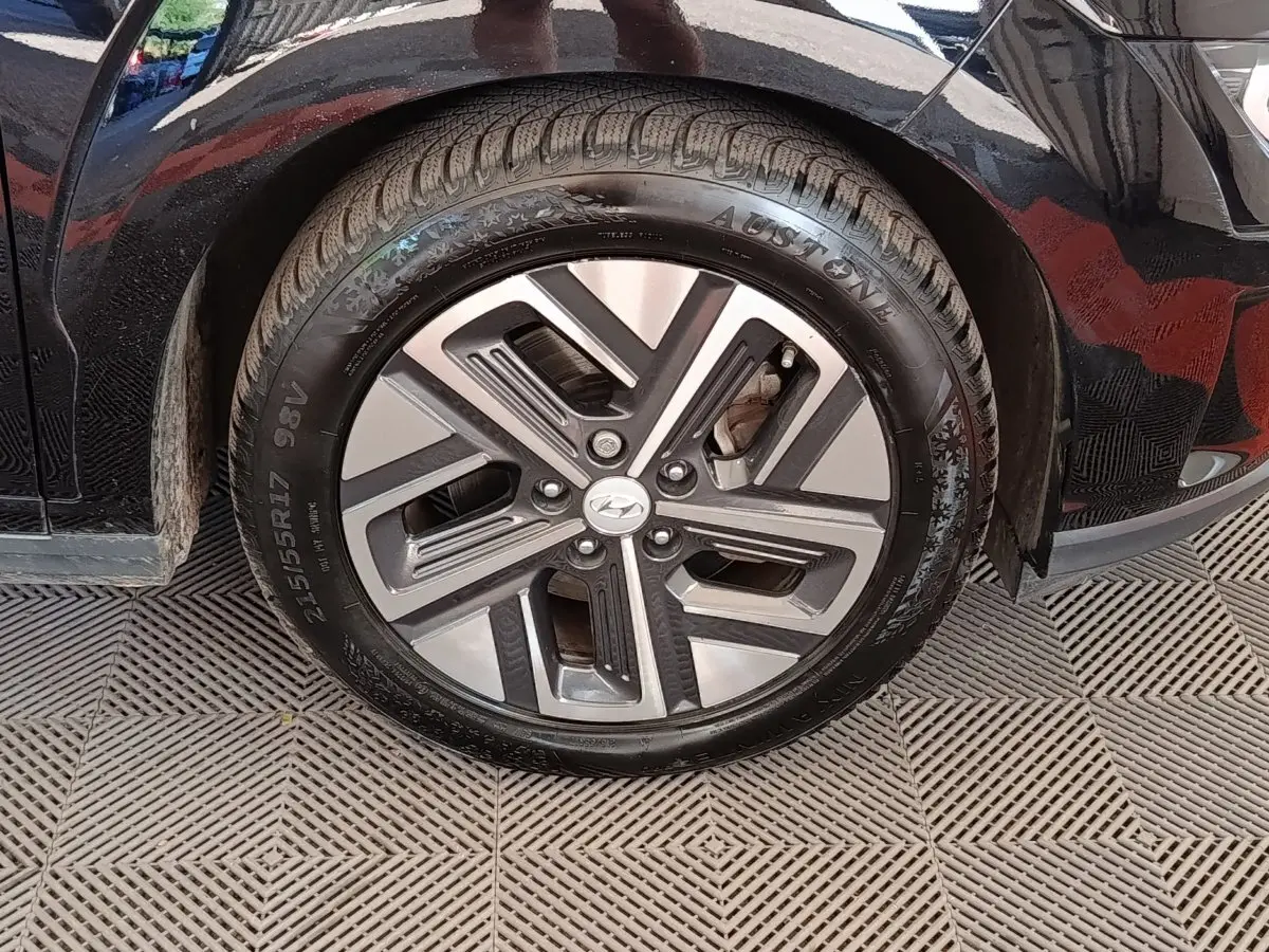 Gros plan sur la roue avant gauche noire d’un Hyundai Kona électrique 2023 avec jante alliage bicolore.