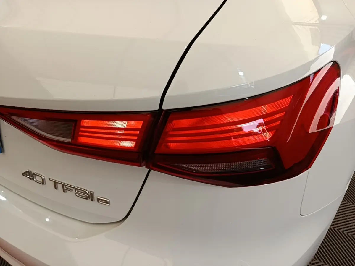 Gros plan sur le feu arrière droit rouge d’une Audi A3 blanche 40 TFSI e avec logo visible sur le coffre.
