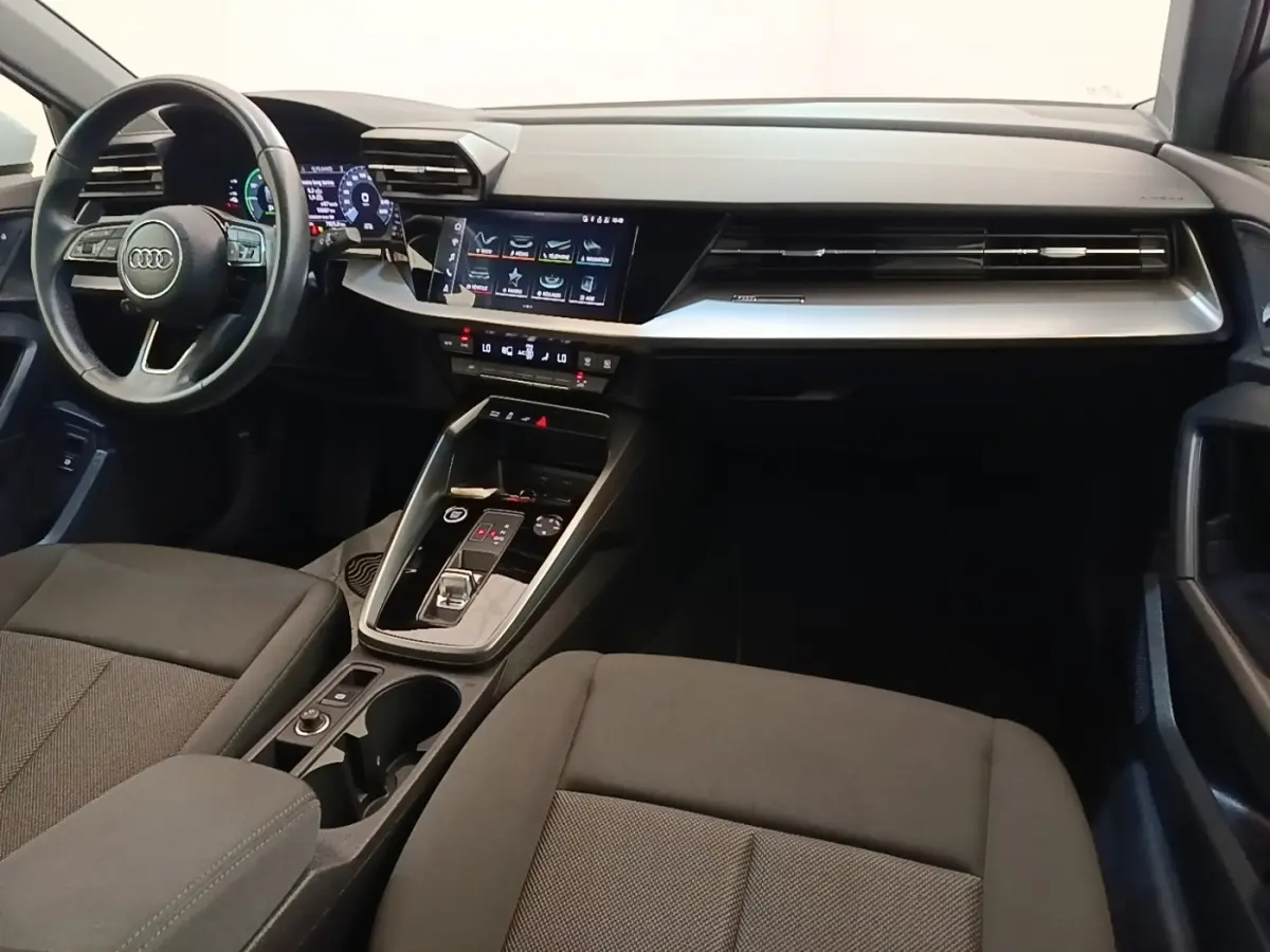 Vue intérieure de l'Audi A3 40 TFSI e 2022, tableau de bord moderne avec écran tactile central et volant cuir noir.
