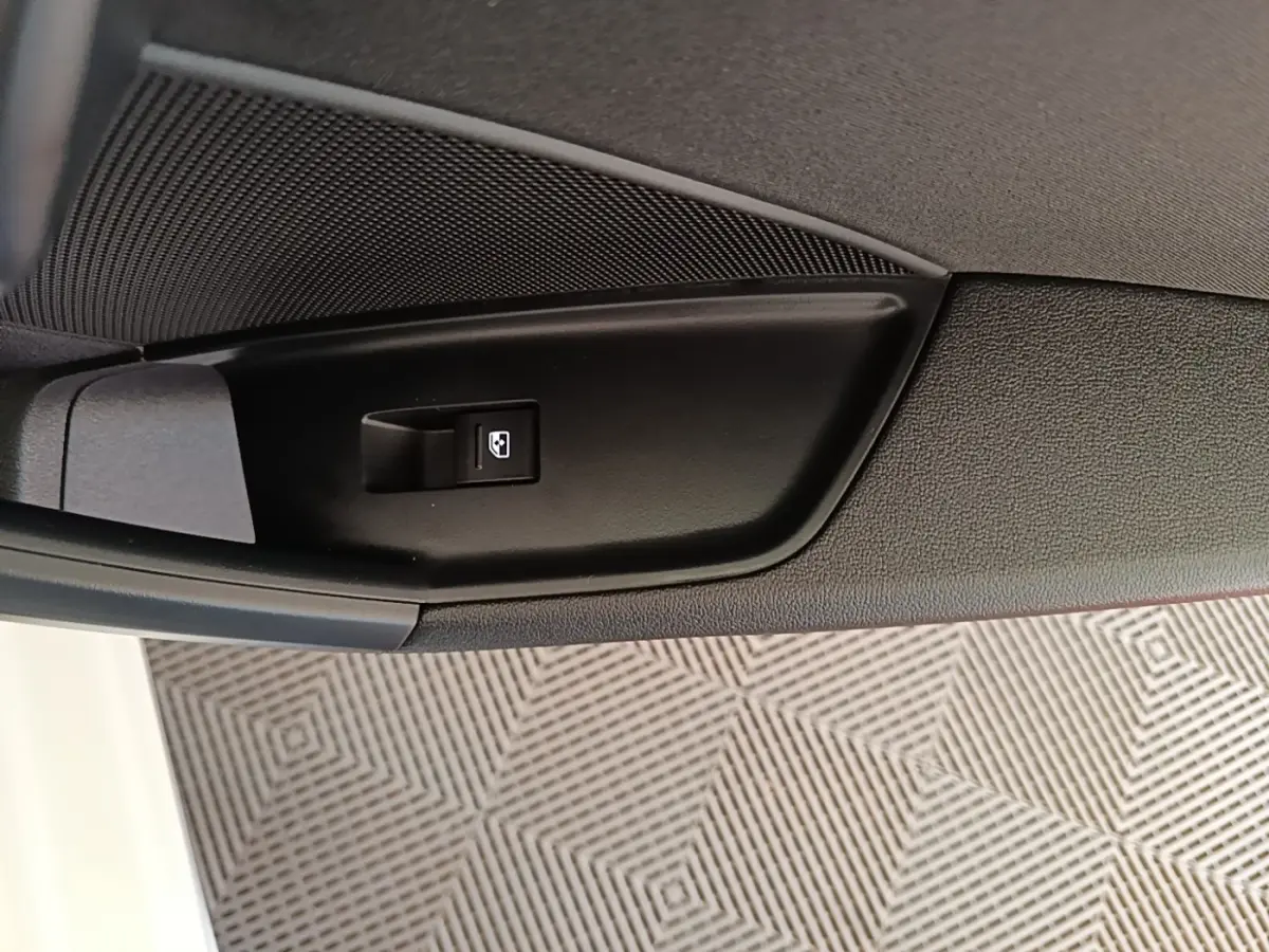 Détail de la commande de lève-vitre électrique côté intérieur d'une Audi A3 blanche hybride rechargeable.
