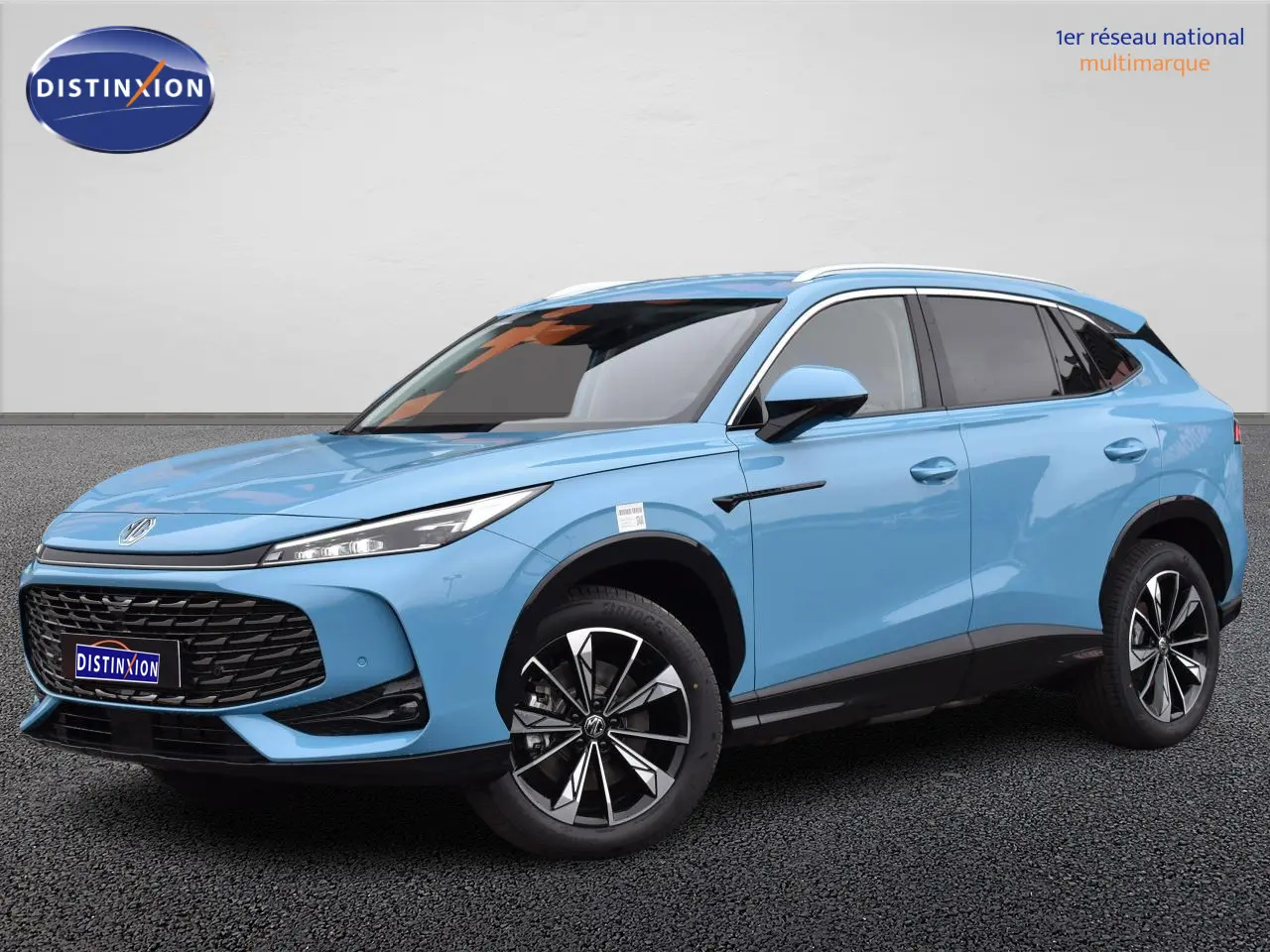 MG Motor EHS 1.5 Hybrid+ bleu en vue 3/4 avant, avec jantes alliage 19 pouces et vitres surteintées.