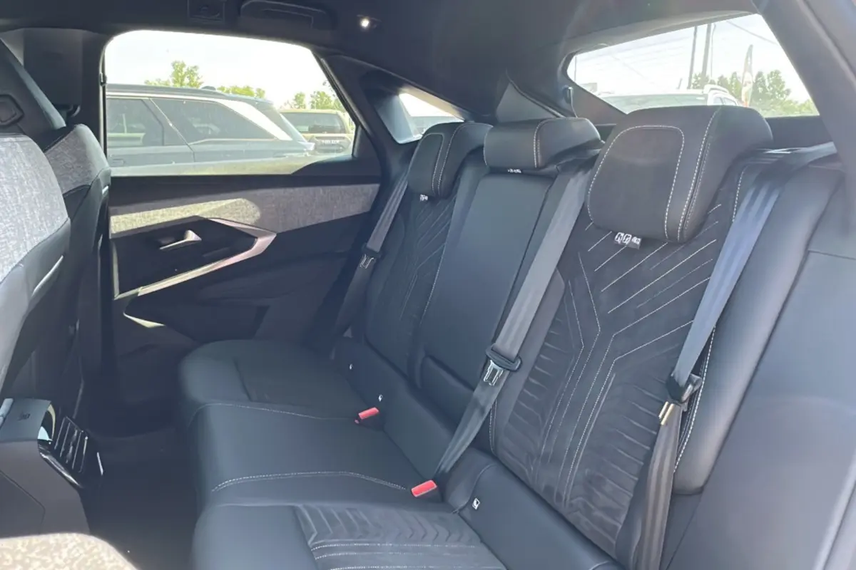 Vue intérieure arrière du Peugeot 3008 Hybrid 145 GT Alcantara 2025 avec sièges noirs en cuir et tissu Alcantara.