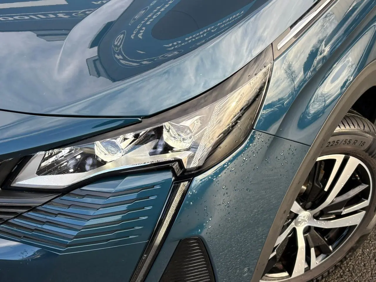 Gros plan sur l'avant droit du Peugeot 3008 bleu Célèbes, mettant en valeur le phare LED et la jante alliage 18 pouces.
