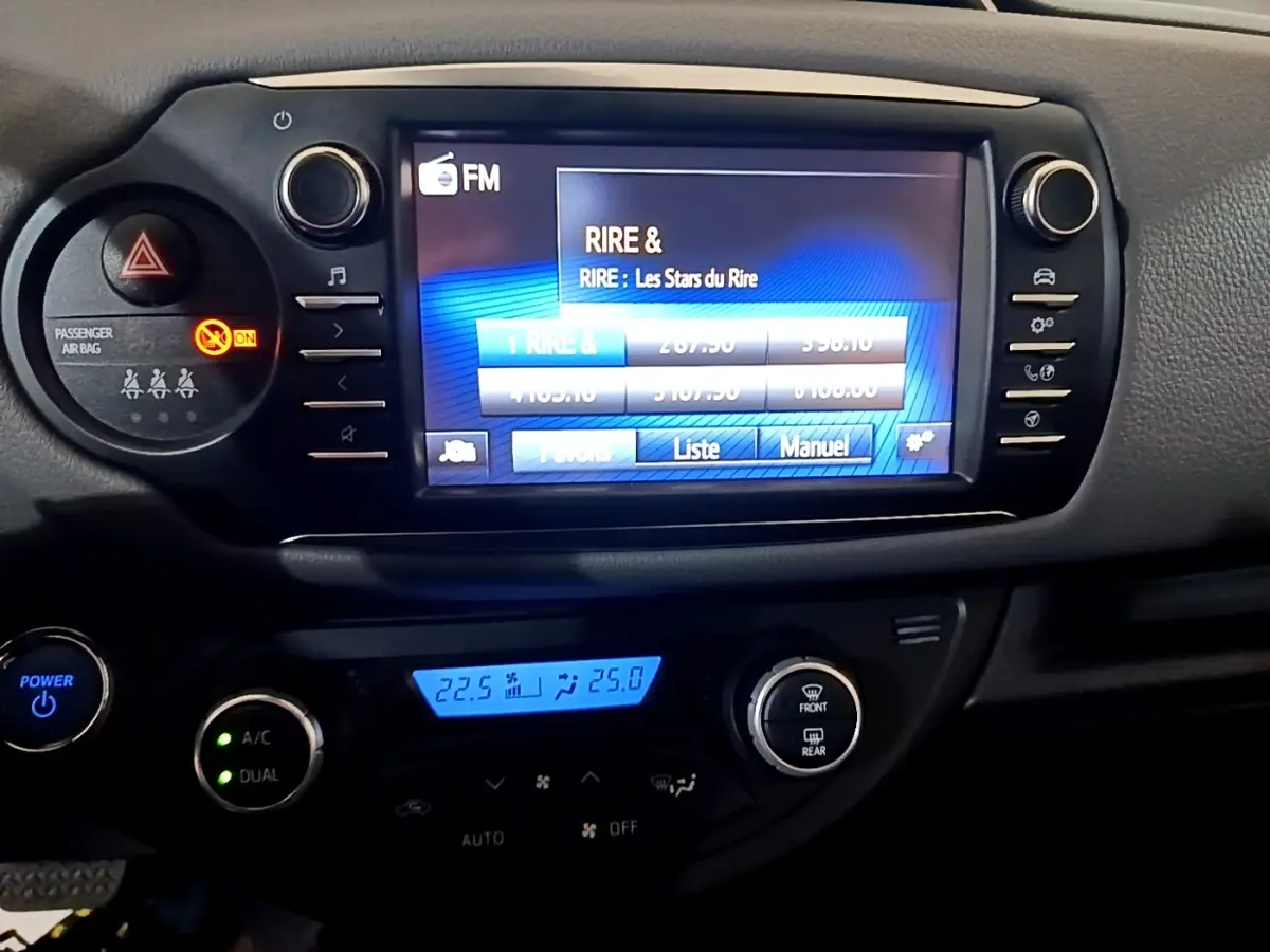 Vue rapprochée du tableau de bord noir de la Toyota Yaris hybride 2019, avec écran tactile et commandes climatisation.