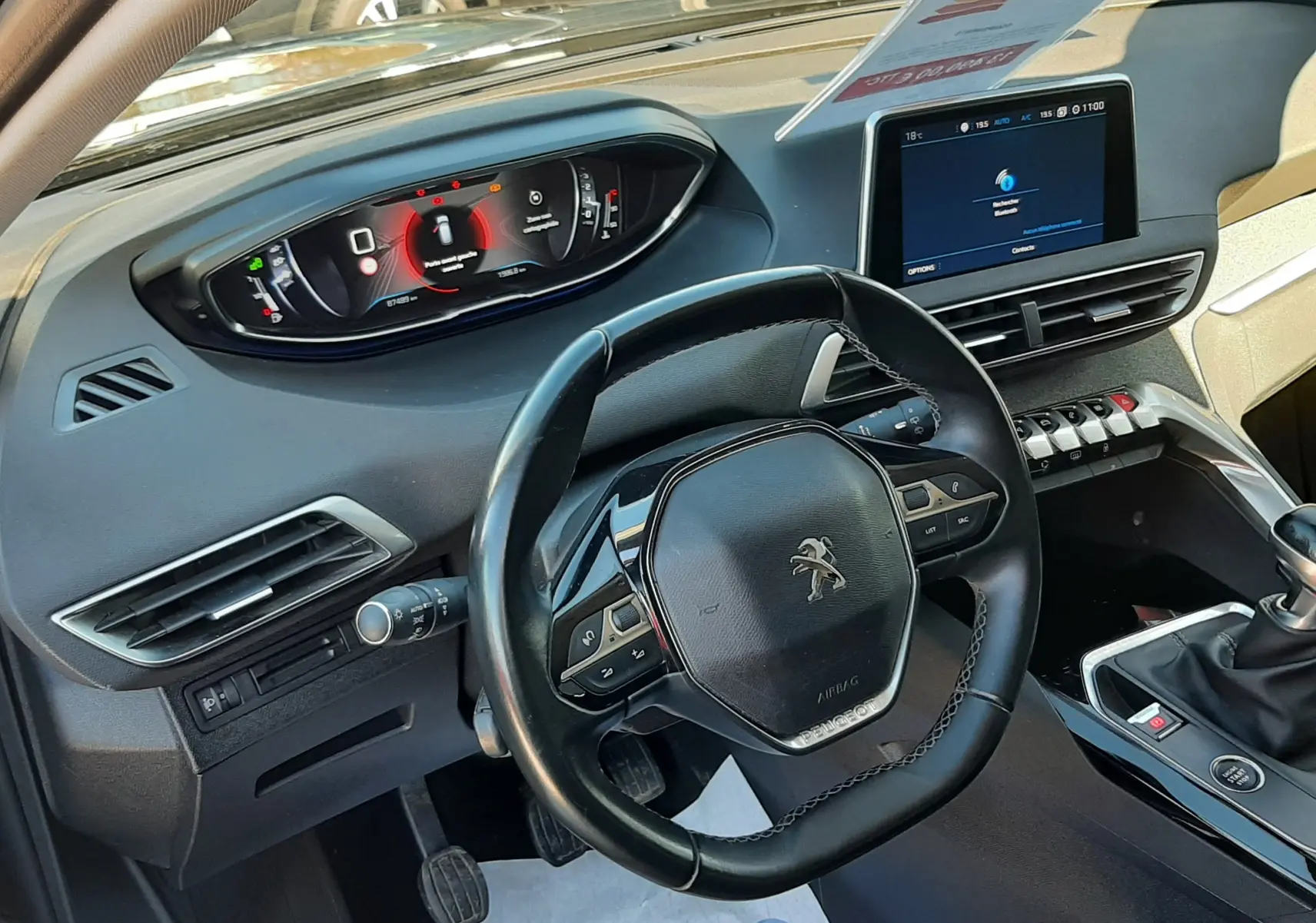 Vue intérieure côté conducteur du Peugeot 3008 noir 2019, mettant en valeur le volant compact et l'écran tactile central.
