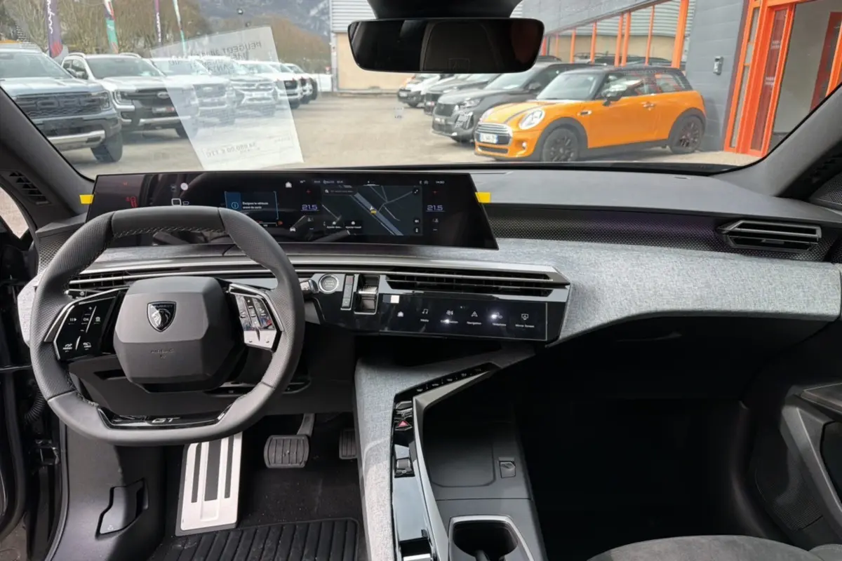 Vue intérieure avant du Peugeot 3008 Hybrid GT Alcantara 2025, tableau de bord moderne avec volant cuir et écran large digital.