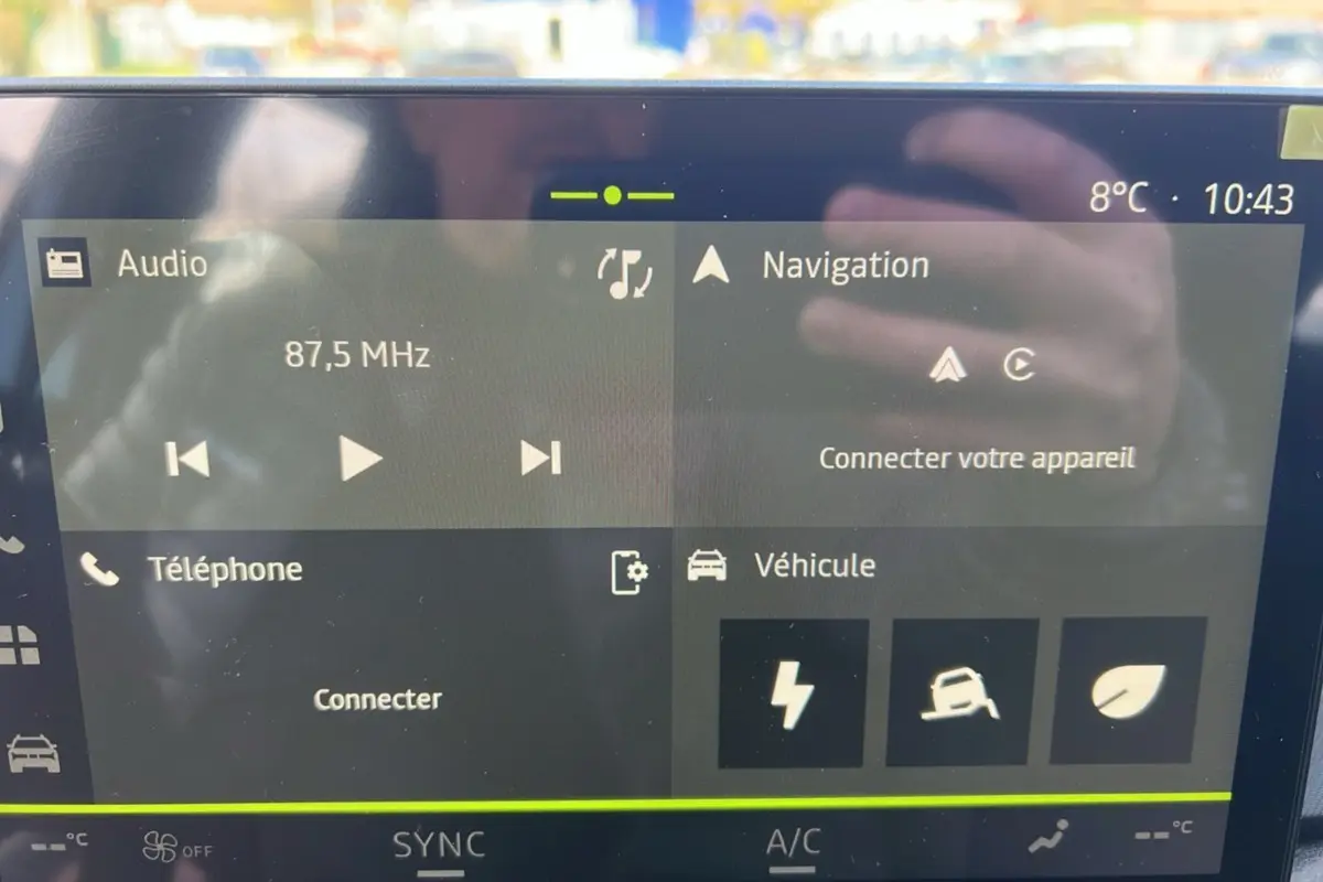 Écran tactile multimédia affichant radio, navigation et connexion téléphone dans un Dacia Bigster hybride 2026.