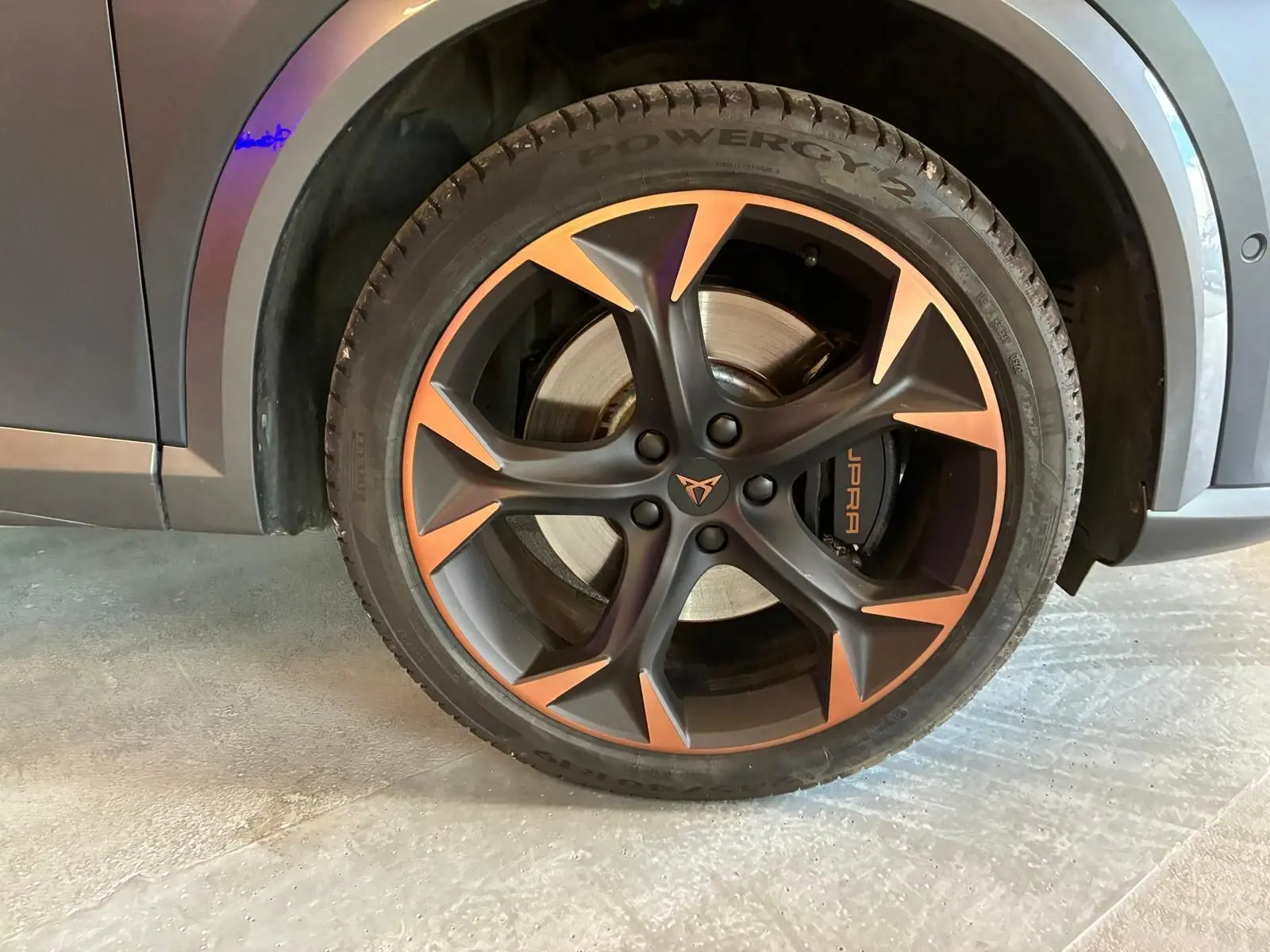 Gros plan sur la roue avant droite d’une CUPRA Formentor gris foncé mat avec jante noire et cuivre, étrier CUPRA visible.