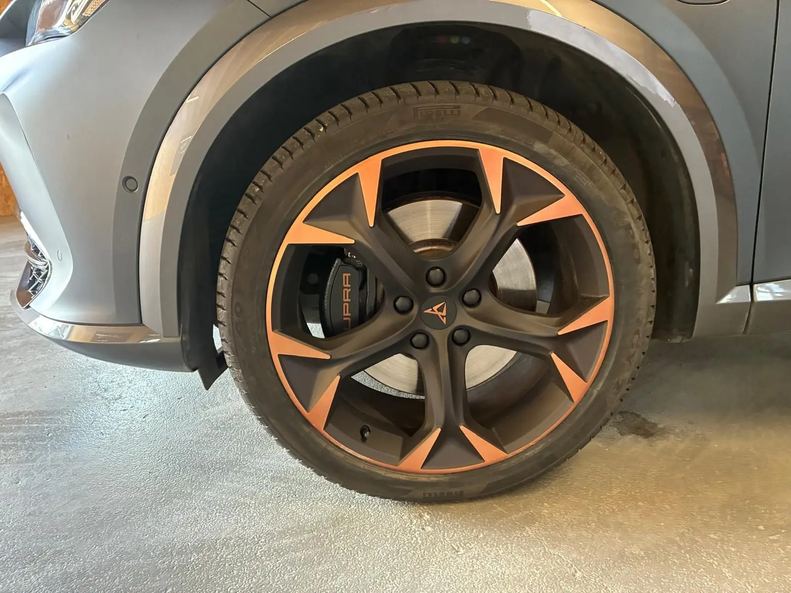 Gros plan sur la roue avant gauche du CUPRA Formentor gris foncé mat, avec jante noire et bronze et étrier de frein marqué CUPRA.