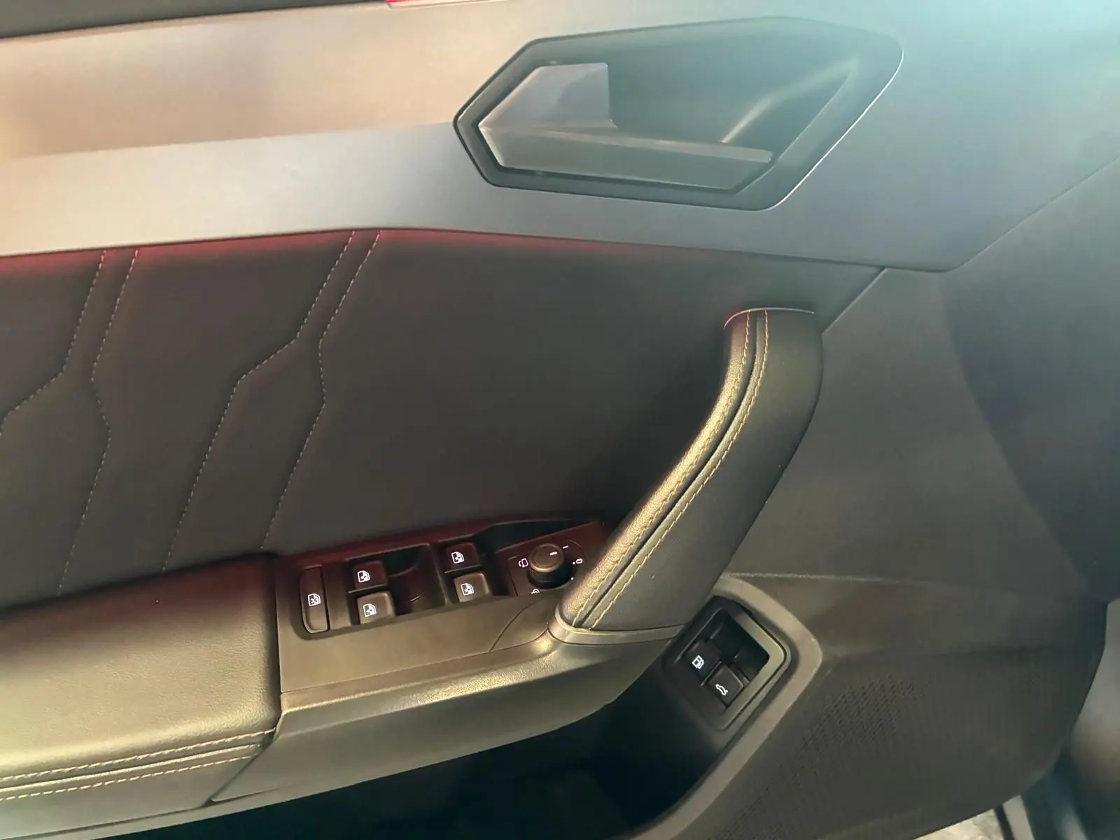Détail de la porte côté conducteur du CUPRA Formentor gris foncé mat 2024, avec commandes des vitres et rétroviseurs.