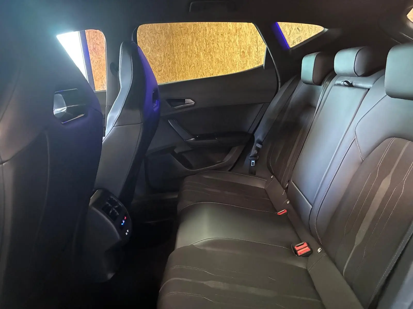 Vue intérieure de la banquette arrière en cuir noir du CUPRA Formentor 1.4 E-HYBRID 2024, avec appuie-têtes et ceintures visibles.