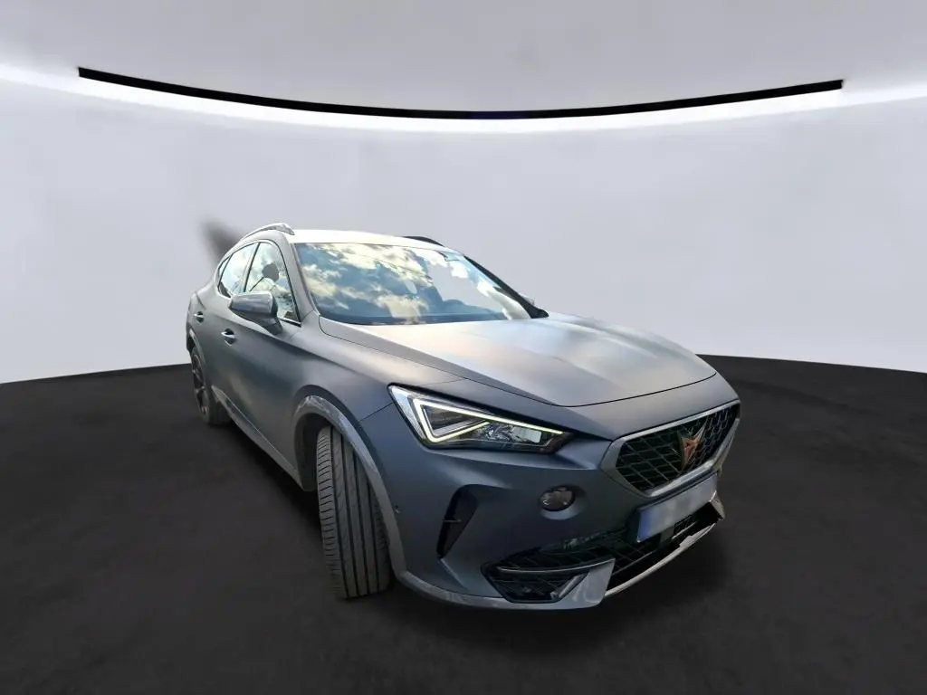 Vue 3/4 avant gauche d'une CUPRA Formentor 1.4 E-HYBRID 245 DSG6 VZ gris foncé mat avec jantes noires et cuivrées.