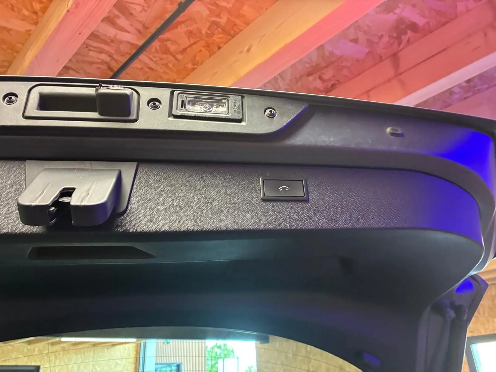 Détail intérieur du hayon ouvert d’une CUPRA Formentor gris foncé mat, montrant la commande d’ouverture électrique.
