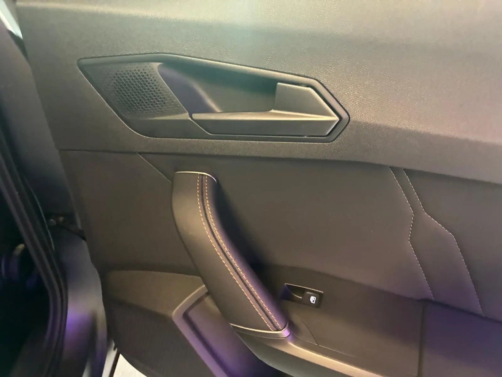 Détail de la poignée de porte intérieure côté gauche du CUPRA Formentor 1.4 E-HYBRID 2024 en cuir noir avec surpiqûres.