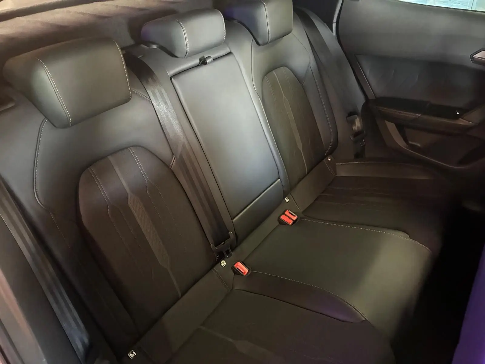 Vue intérieure arrière des sièges en cuir noir de la CUPRA Formentor 1.4 E-HYBRID 245 DSG6 VZ, avec ceintures et appuie-têtes.