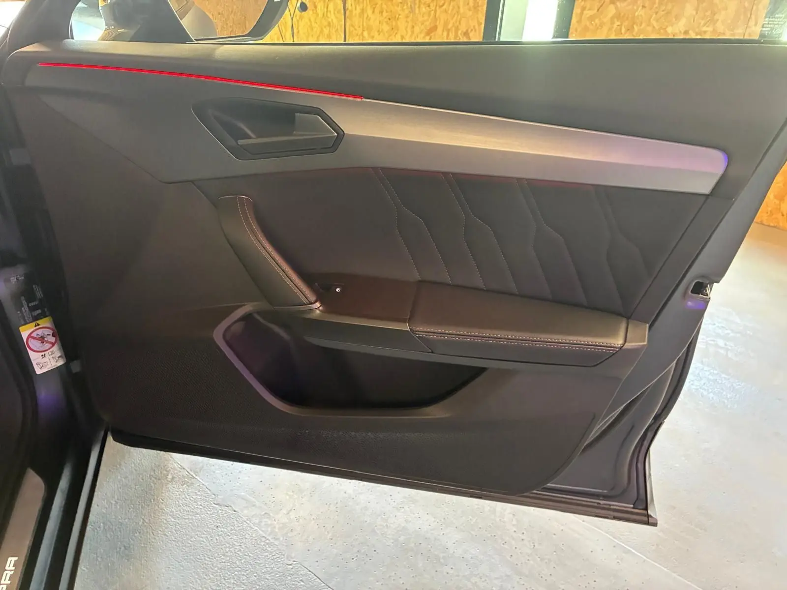 Vue rapprochée de la porte avant gauche intérieure noire avec surpiqûres contrastantes du CUPRA Formentor gris foncé mat 2024.