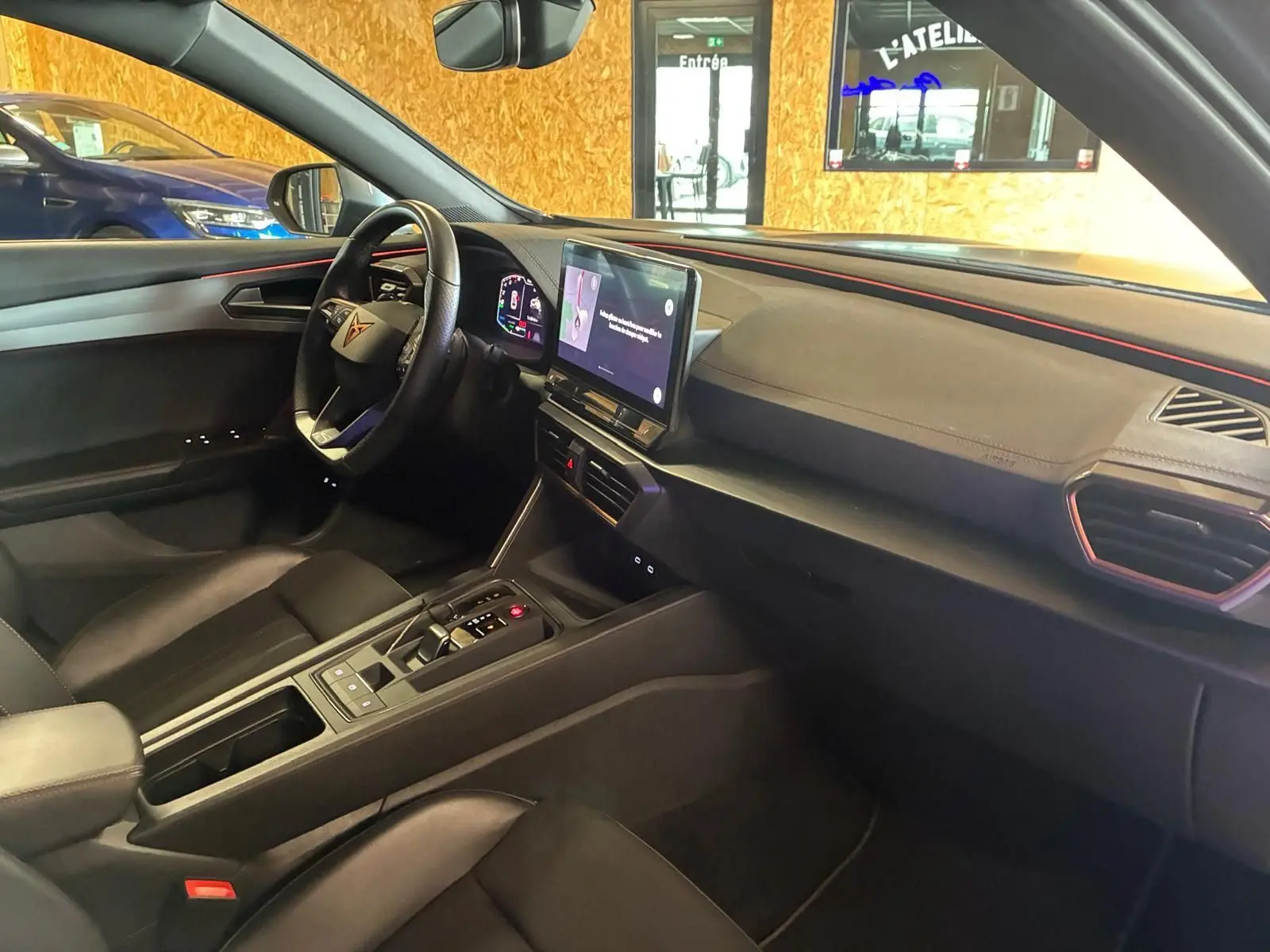 Vue intérieure côté conducteur de la CUPRA Formentor 1.4 E-HYBRID 2024 avec tableau de bord noir et écran tactile central.