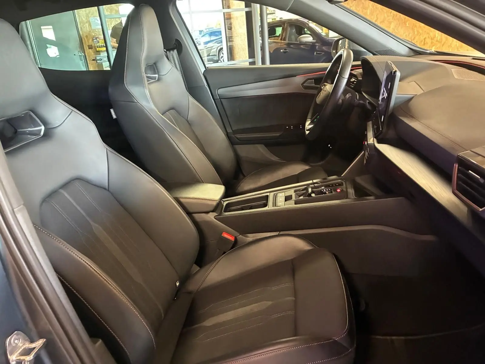 Vue intérieure côté conducteur du CUPRA Formentor 1.4 E-HYBRID 245 DSG6, sièges noirs et tableau de bord moderne.