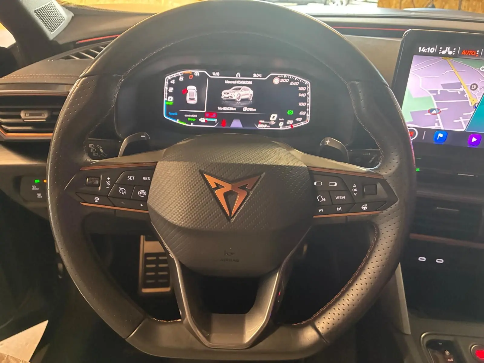 Vue rapprochée du volant en cuir noir perforé avec logo CUPRA cuivré et tableau de bord numérique du Formentor 1.4 hybride.