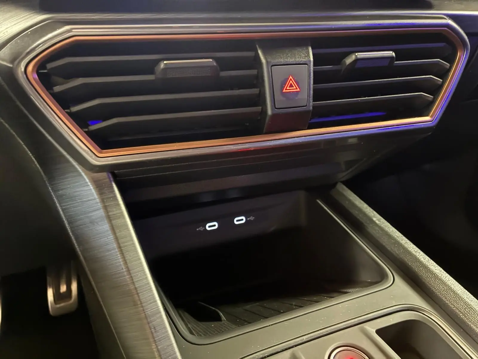 Gros plan sur la console centrale noire du CUPRA Formentor 1.4 E-HYBRID 2024 avec prises USB-C et bouton de warning.