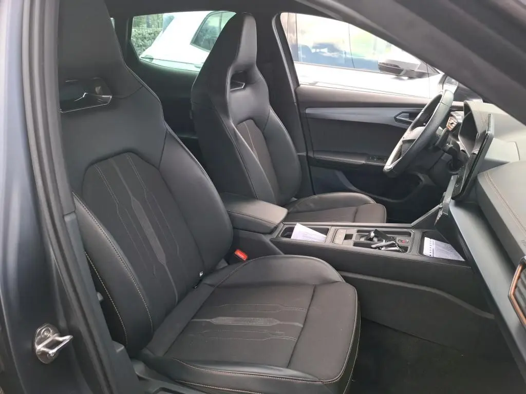 Vue arrière d'une CUPRA Formentor 1.4 E-HYBRID 245 DSG6 VZ gris foncé mat avec feux arrière LED allumés en intérieur.