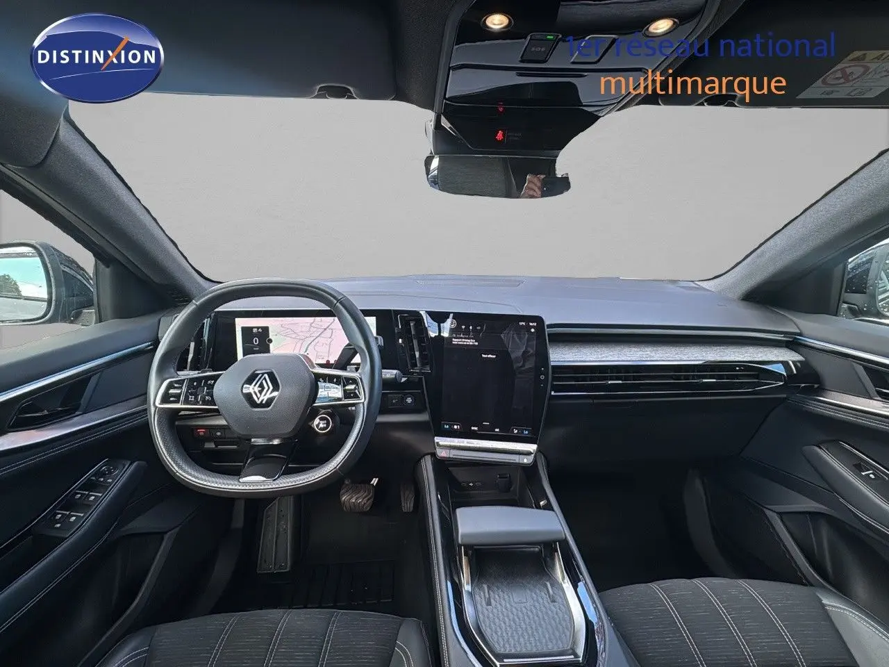 Vue intérieure avant du Renault Austral 2023 gris schiste, tableau de bord moderne avec écran tactile vertical et volant multifonction.