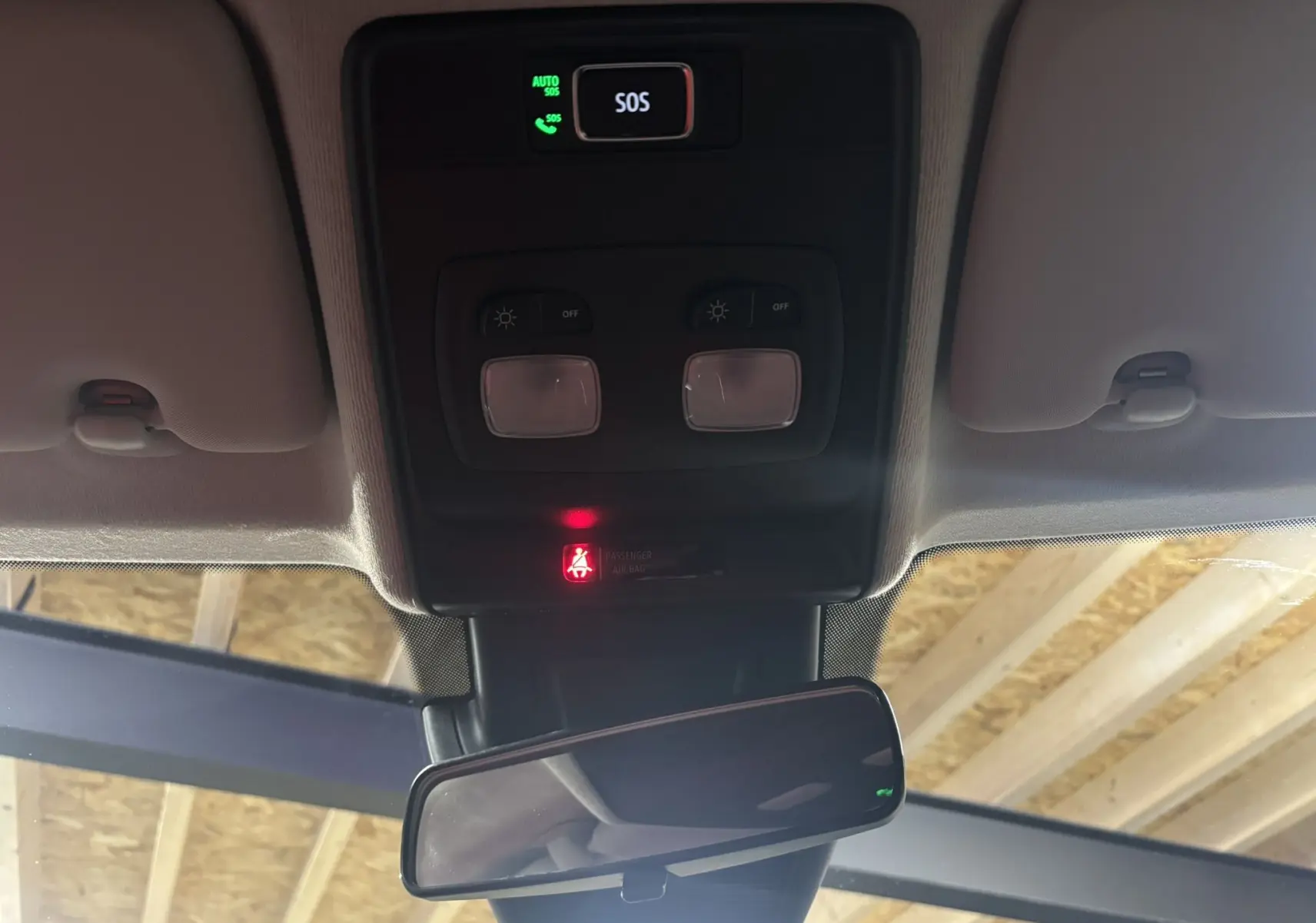 Vue intérieure du plafond d'une Renault Clio 2024 bleu Iron, montrant les commandes d'éclairage et le rétroviseur central.