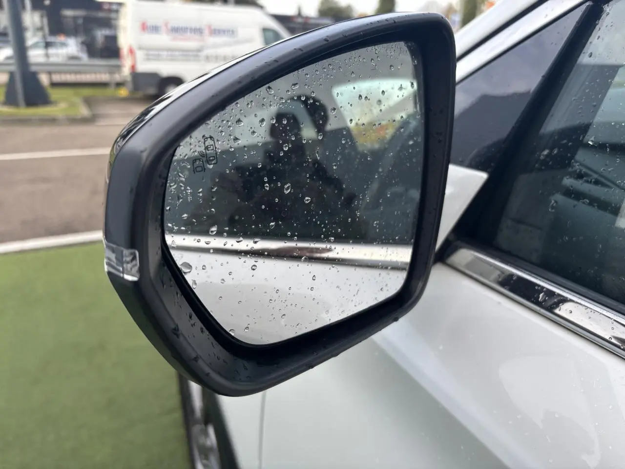 Rétroviseur extérieur côté gauche blanc nacré du DS7 Crossback 2021 avec gouttes de pluie visibles.