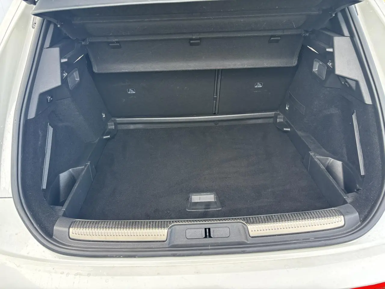 Coffre ouvert du DS7 Crossback blanc, vue arrière montrant un espace de chargement spacieux et bien fini.