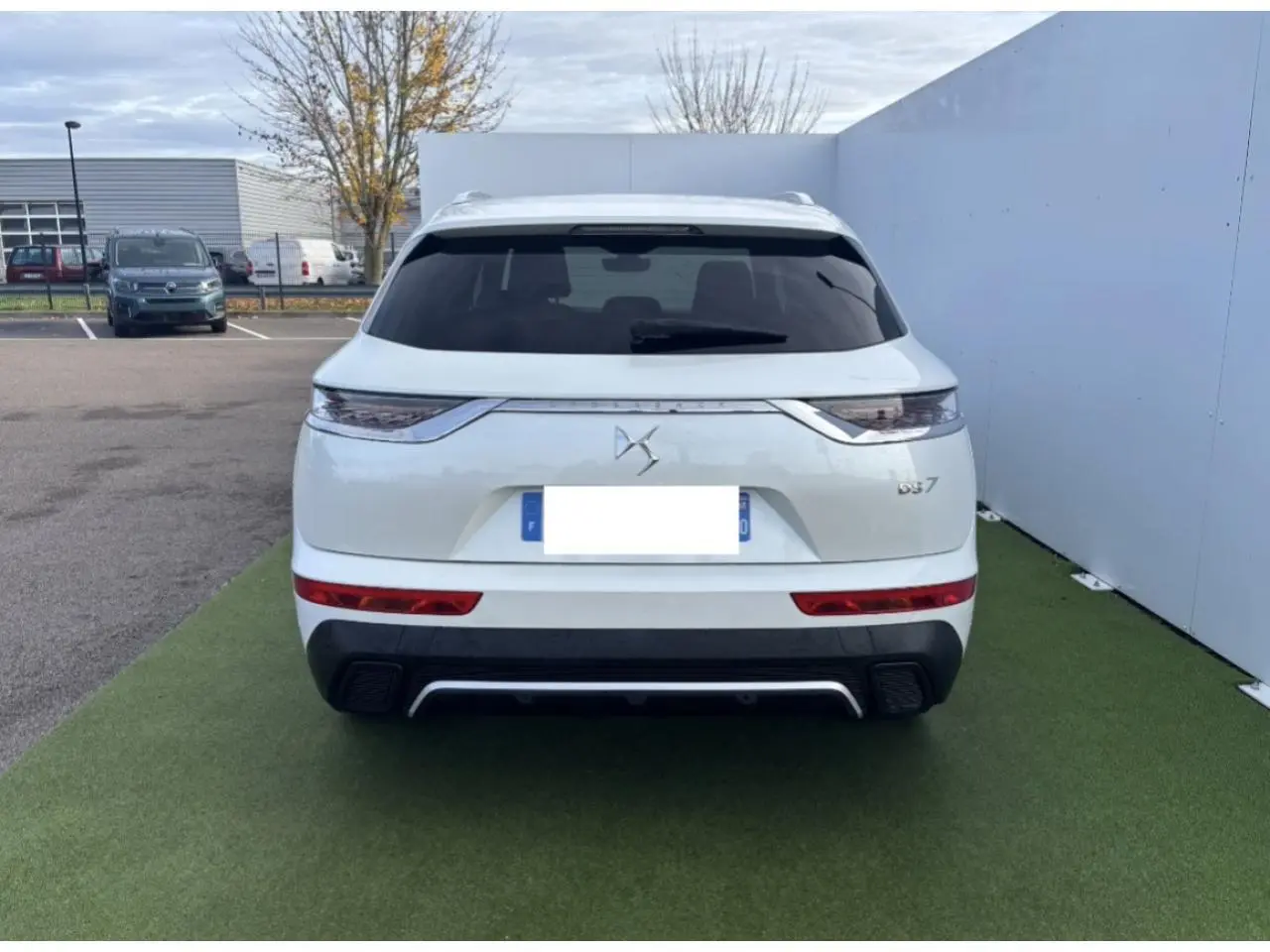 Vue arrière d'un DS7 Crossback blanc nacré avec feux arrière 3D et lunette arrière surteintée.