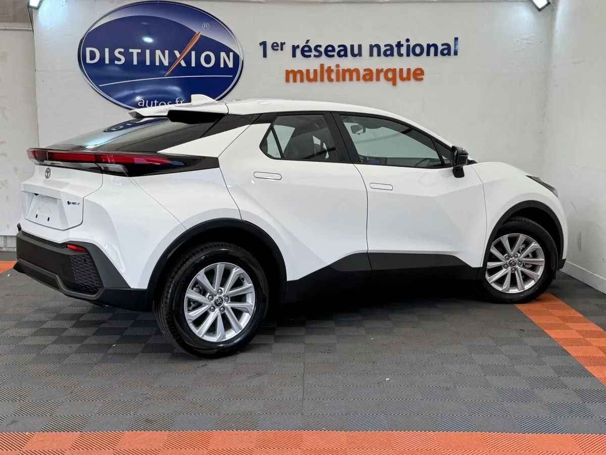 Vue latérale droite du Toyota C-HR 1.8 Hybride blanc 2024 avec lignes anguleuses et jantes alliage.